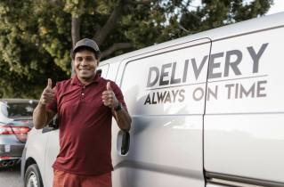 Smiling Delivery Driver Standing in Front of a Van